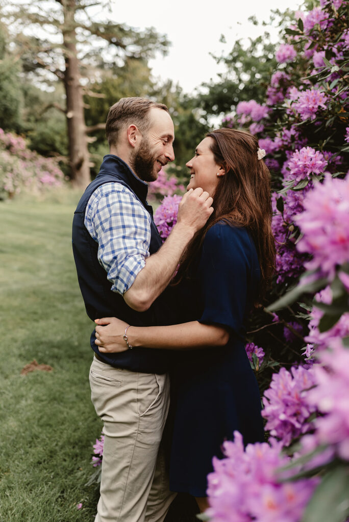 couple facing each other and talking while near the purple flowers