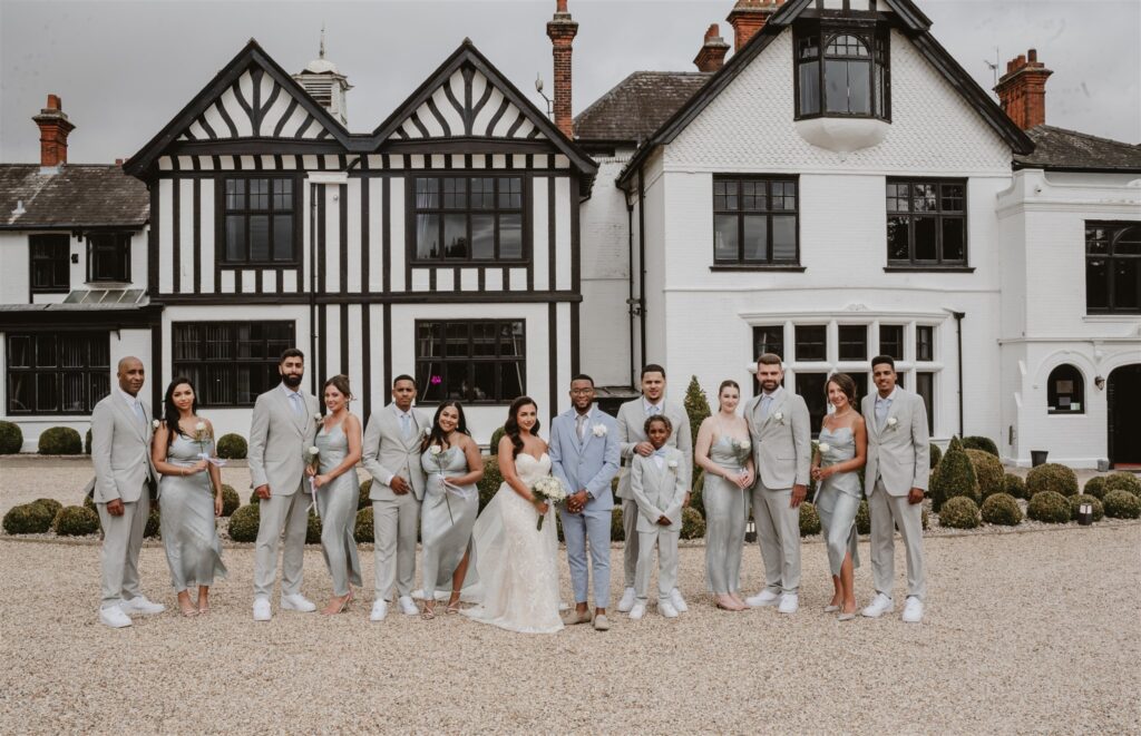 wedding party standing with bride and groom outside their wedding venue