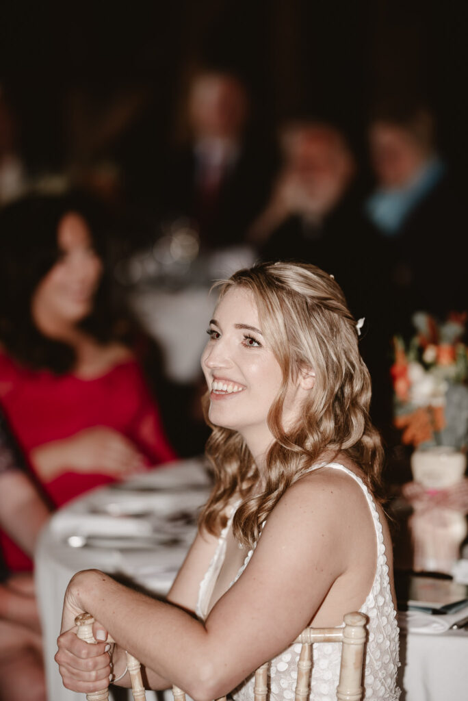 bride smiling during wedding speeches