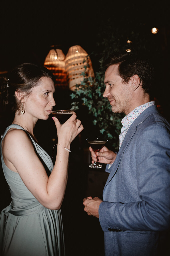 wedding guests looking at each other and drinking cocktails