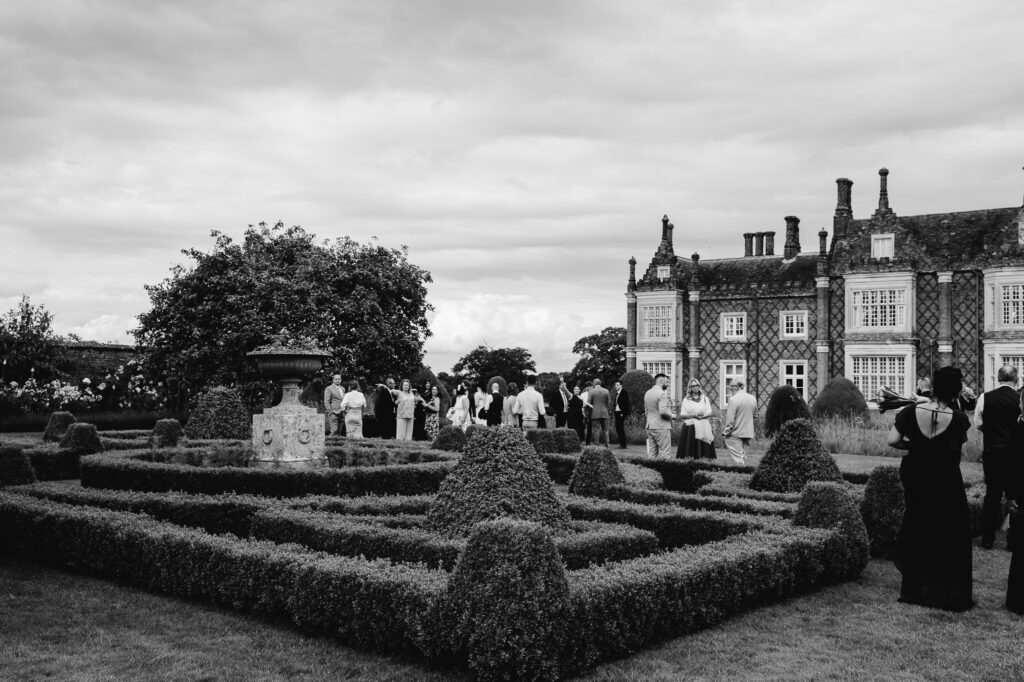 black and white image of gardens and venue home with guests