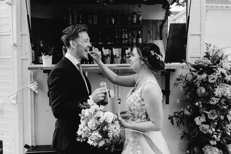 black and white image of bride feeding the groom