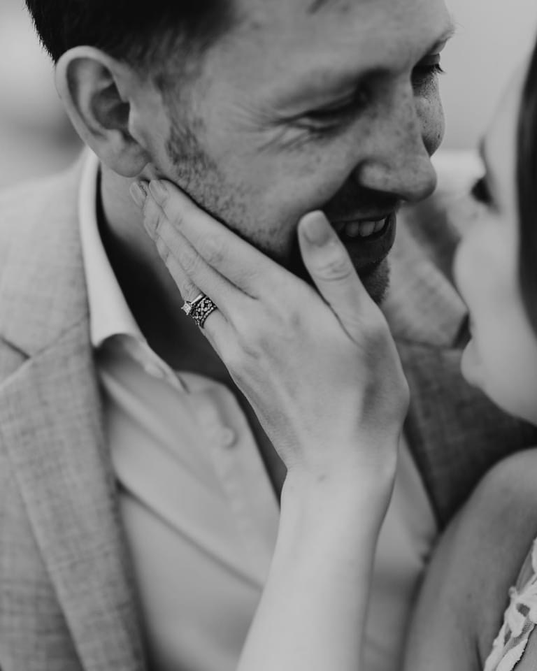 black and white image of bride holding grooms face close up