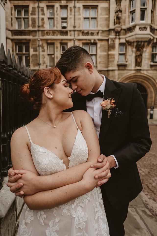 bride and groom touching noses in the middle of Cambridge city