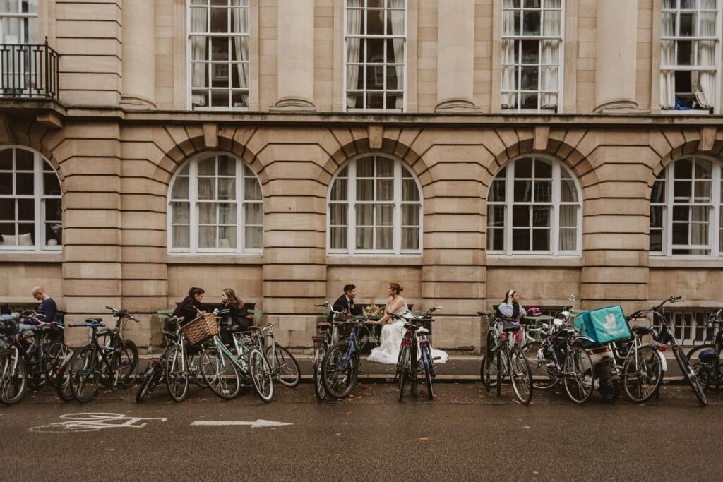 bride and groom sitting at a local Cambridge coffee shop in front of a row of bikes